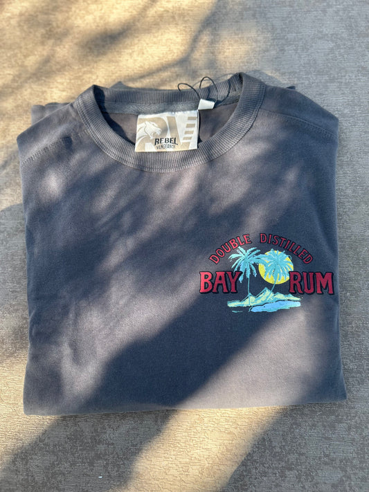 Folded dark gray sweatshirt with 'Double Distilled Bay Rum' text and palm tree design on a textured surface.