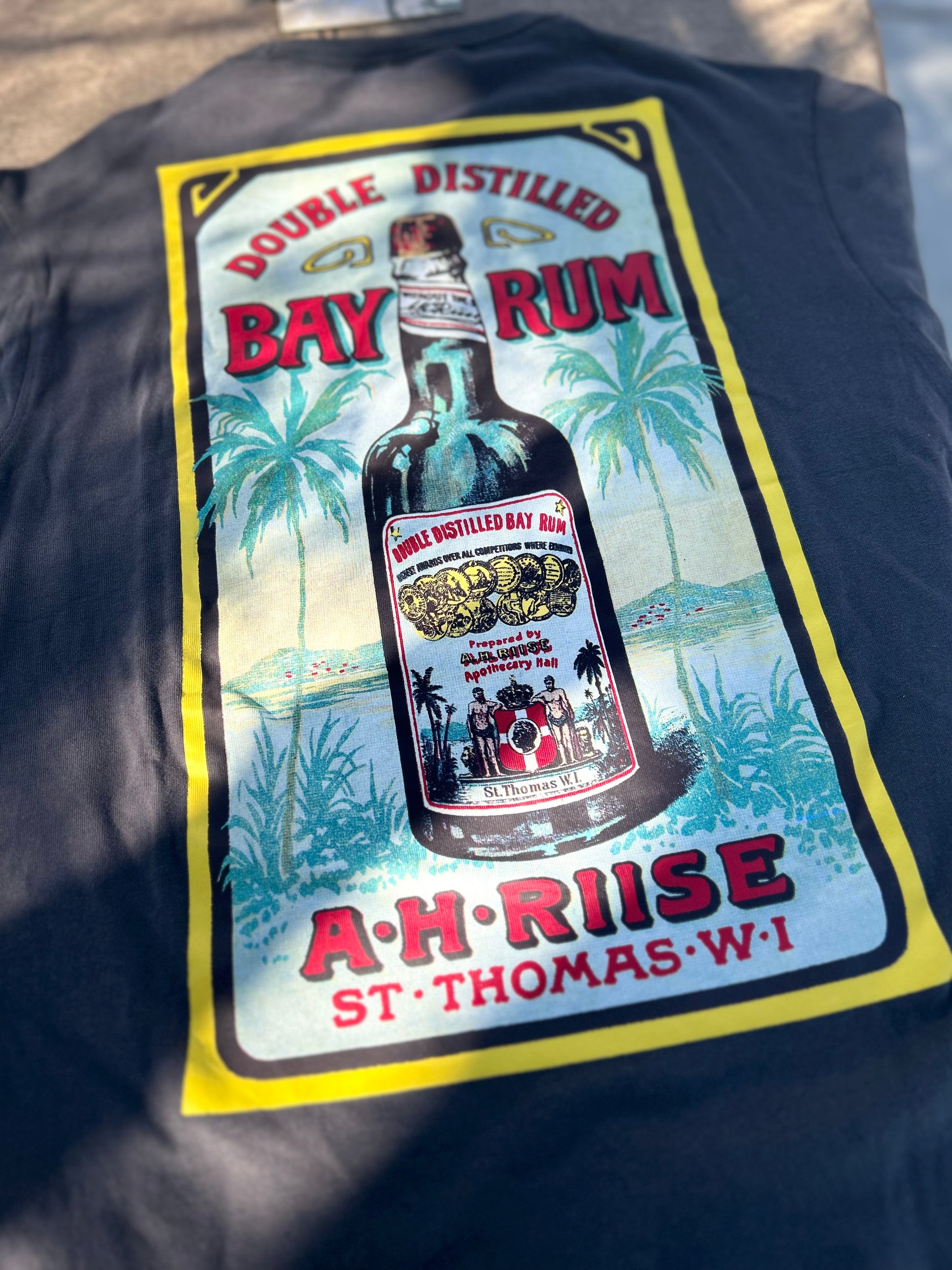 A shirt with a Bay Rum label design featuring a bottle and tropical scenery.